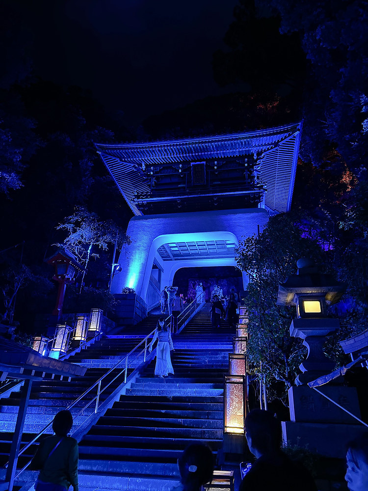 Enoshima's Zuishinmon gate lit in blue at night, with stone stairs leading up