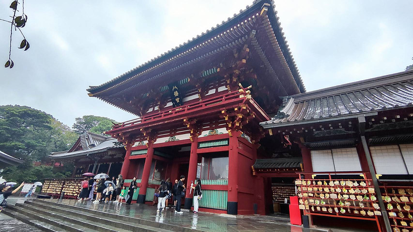 The red main shrine building of Tsurugaoka Hachimangu in the rain