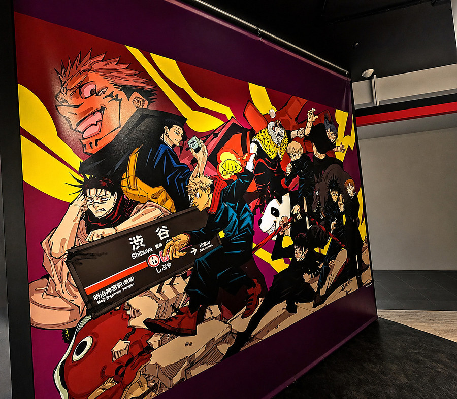 Large Jujutsu Kaisen anime mural inside a Shibuya pop-culture store